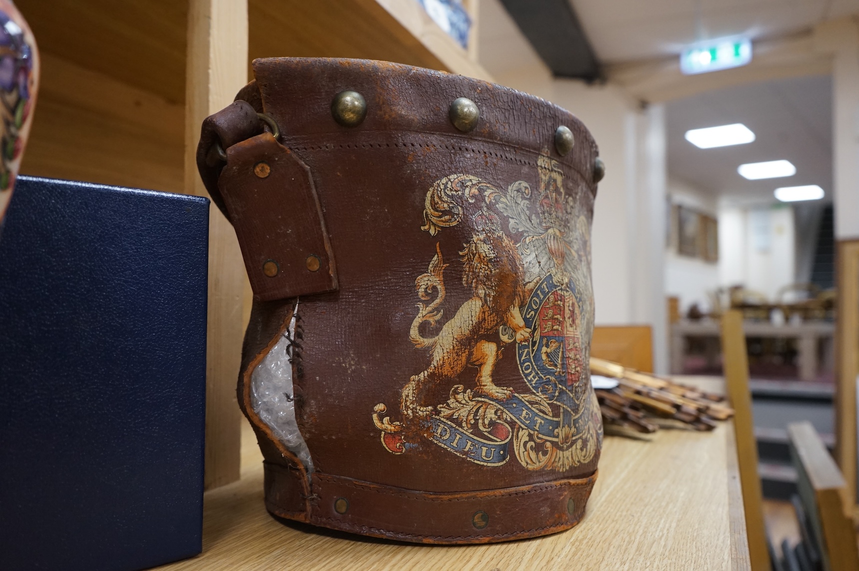 A brown leather fire bucket with Royal Coat of Arms decoration, 25cm high